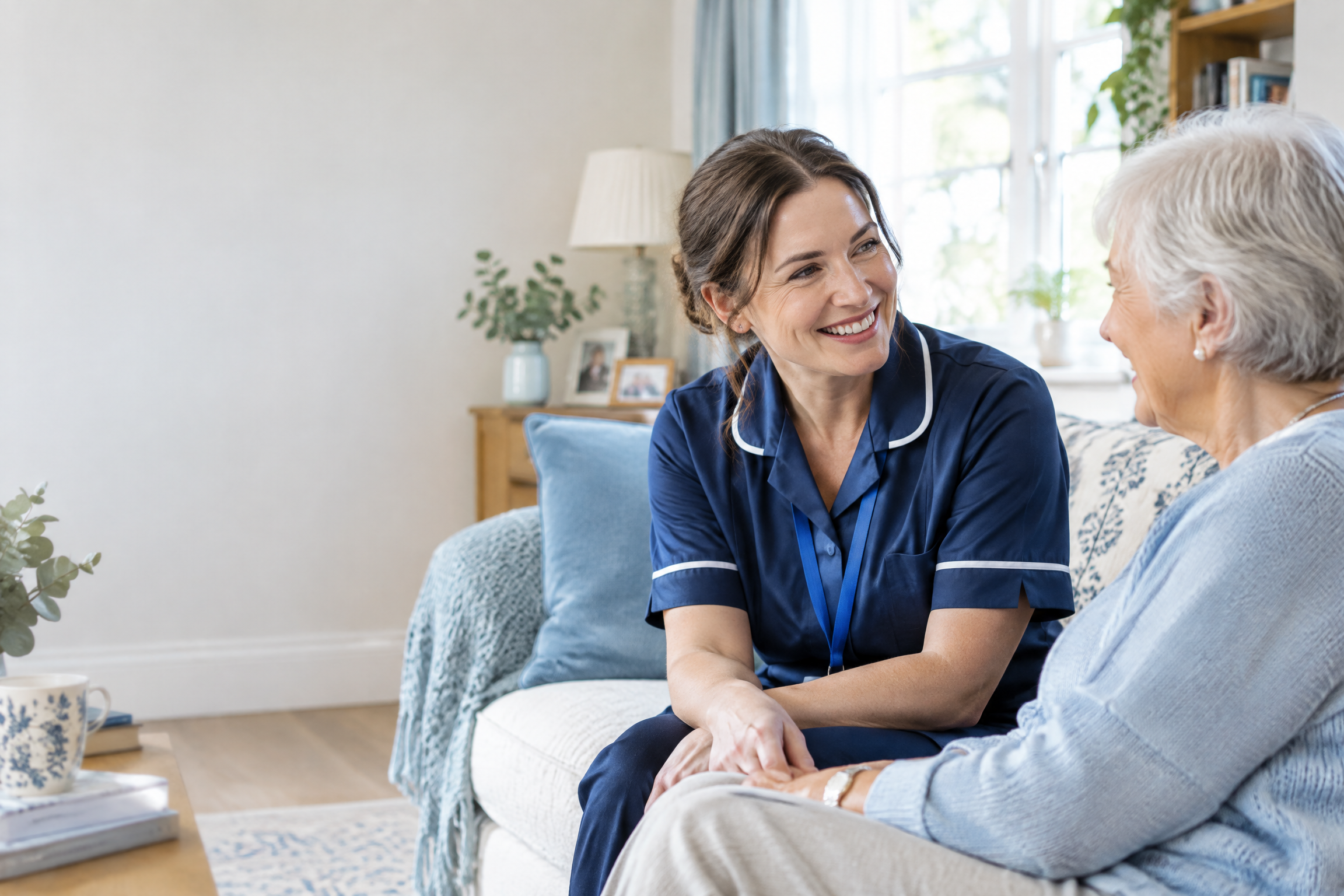 A community care professional talking with an older woman at home